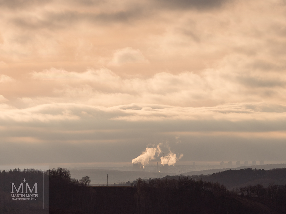 Clouds over the landscape, a factory in the distance. Photograph created with the Olympus M. Zuiko digital ED 40 - 150 mm 1:2.8 PRO.